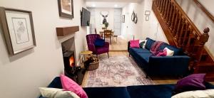 un soggiorno con divano blu e sedie viola di Atlantic Way Cottage a Galway