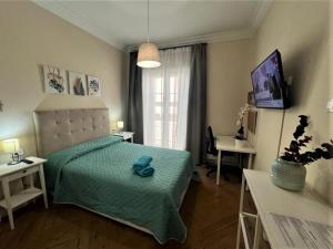 Un dormitorio con una cama verde con un animal de peluche azul. en Alojamiento Don Ramón, en Madrid