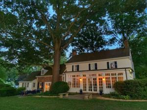 ein großes weißes Haus mit einem Baum davor in der Unterkunft Blake House Historic Estate with Private Inn in Centreville