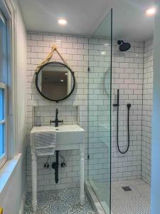 uma casa de banho com um lavatório e um chuveiro com um espelho. em Blake House Historic Estate with Private Inn em Centreville
