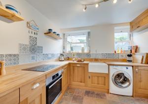 uma cozinha com armários de madeira e uma máquina de lavar e secar roupa em Karrys em Lynmouth