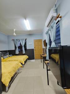 une chambre d'hôpital avec quatre lits d'une rangée dans l'établissement TBE Room2stay at Jalan BR3, à Malacca