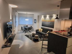 la suite oasi di relax e comfort IUN R1091 في أوريستانو: مطبخ وغرفة معيشة مع أريكة وطاولة