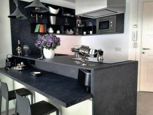 a kitchen with a black counter with flowers on it at la suite oasi di relax e comfort IUN R1091 in Oristano