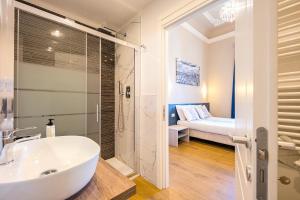 un bagno con lavandino e doccia e un letto di Boutique Hotel Bijou a Firenze