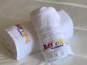 2 rollos de papel higiénico blanco en una cama en BayView Albufeira, en Albufeira