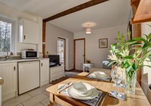 a kitchen and living room with a table and a table sidx sidx sidx at Kingfisher Cottage in East Down