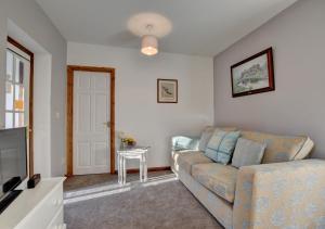 a living room with a couch and a table at Kingfisher Cottage in East Down