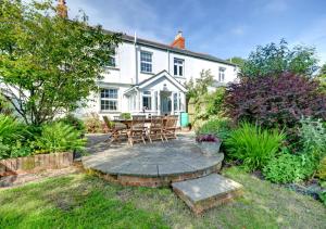 a house with a patio with a table and chairs at Laurel Cottage in Parracombe