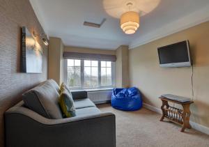 a living room with a couch and a tv at Keepers Cottage Lynton in Barbrook