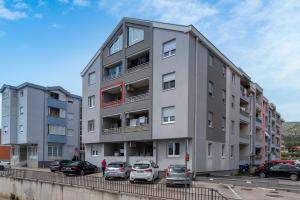 een appartementencomplex met auto's geparkeerd op een parkeerplaats bij Apartman Marino in Trogir