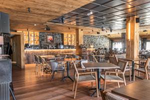 a restaurant with tables and chairs and a bar at Snö Hotel Formigal in Formigal