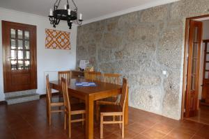 uma sala de jantar com uma mesa de madeira e cadeiras em Casa nos Penedos em Arcos de Valdevez