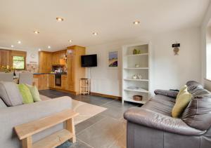 a living room with a couch and a kitchen at Devon Longstraw in Croyde