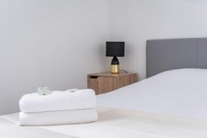 a bedroom with a bed and a nightstand with towels at Le Fournil - WiFi - Séjournez à proximité de tout in Schiltigheim