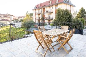 drewniany stół i krzesła na balkonie w obiekcie Elite Home w mieście Monfalcone