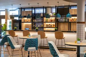 un ristorante con tavoli e sedie e un bar di Hotel München City Center affiliated by Meliá a Monaco