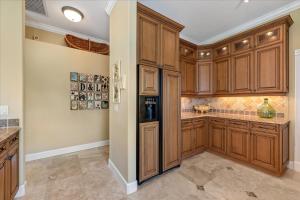 a large kitchen with wooden cabinets and a tile floor at Ocean Vue By Beachside Management in Siesta Key
