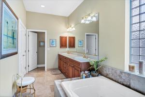 a bathroom with a tub and a sink and a mirror at Ocean Vue By Beachside Management in Siesta Key