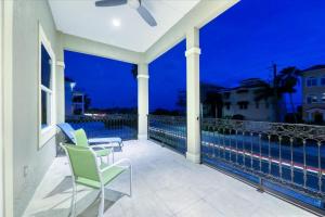 a balcony with chairs and a view of the ocean at night at Ocean Vue By Beachside Management in Siesta Key