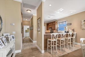 a kitchen and dining room with a bar and chairs at Ocean Vue By Beachside Management in Siesta Key