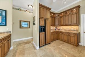 a large kitchen with wooden cabinets and tile floors at Ocean Vue By Beachside Management in Siesta Key