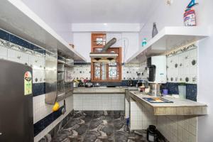 una grande cucina con pareti piastrellate in blu e bianco di BimBan's- A cozy little place a Guwahati