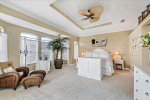 a bedroom with a white bed and a ceiling fan at Ocean Vue By Beachside Management in Siesta Key