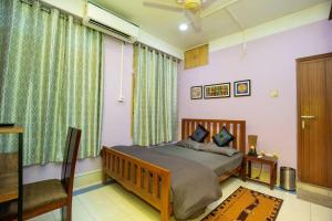 una camera con letto e finestra con tende verdi di BimBan's- A cozy little place a Guwahati