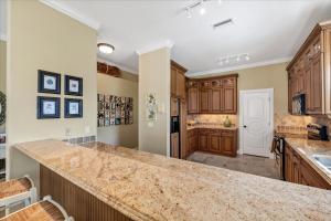 a kitchen with wooden cabinets and a large counter top at Ocean Vue By Beachside Management in Siesta Key