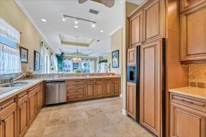 a large kitchen with wooden cabinets and stainless steel appliances at Ocean Vue By Beachside Management in Siesta Key
