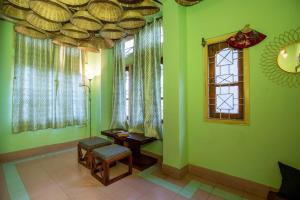 una camera con pareti verdi, tavolo e finestre di BimBan's- A cozy little place a Guwahati