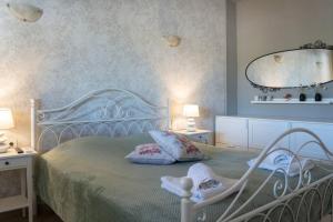 a bedroom with a white bed with two pillows at Merastri Villa in Zaros