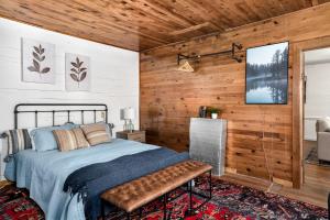 1 dormitorio con 1 cama y pared de madera en River Access Cabin Hot Tub Fast WiFi Fire Pit en Lost City