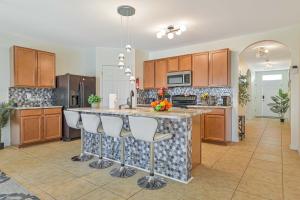 a kitchen with a large island with bar stools at VILLA AWESOME! in Cape Coral