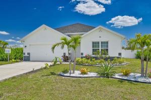 a white house with palm trees in front of it at VILLA AWESOME! in Cape Coral
