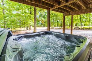 a hot tub in the middle of a backyard at Modern w Fire Pit Deck, Grill & Hot Tub in Berkeley Springs