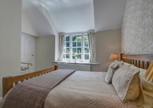 a bedroom with a large bed and a window at Mariners in Barbrook