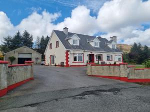 a large white house with a fence in front of it at Kelmin House in Letterkenny