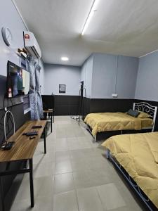 um quarto de hospital com duas camas e uma mesa em TBE Room2stay at Jalan BR3 em Malaca