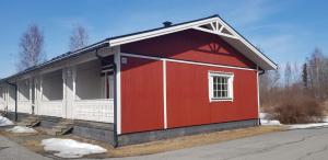 - un bâtiment rouge et blanc avec une terrasse couverte dans l'établissement Vuolteentie, à Kauhajoki