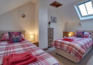 a bedroom with two beds and a dresser at Mill Barn in Bishops Nympton
