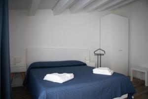 een slaapkamer met een blauw bed en handdoeken bij CASA MAIOLICA in Modica