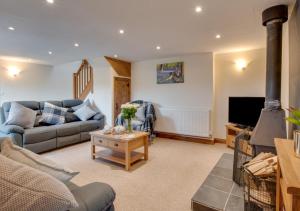 a living room with a couch and a tv at Mill Barn in Bishops Nympton