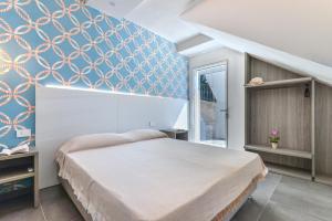 a bedroom with a bed and a blue wall at Villa Serena vista mare in Lacona