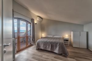 a bedroom with a bed and a sliding glass door at Bellaria Rooms in Montalcino