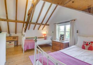 1 dormitorio con 2 camas y ventana en Mill Cottage, en Parracombe