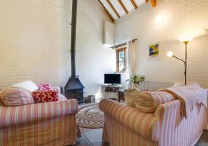 sala de estar con 2 sofás y chimenea en Mill Cottage, en Parracombe