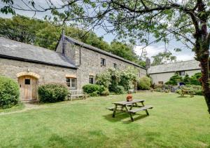 a picnic table in the yard of a stone building at Mill Cottage in Parracombe