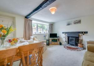 a living room with a table and a fireplace at Waterside Cottage Westleigh in Westleigh